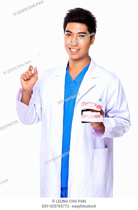 Dentist holding with denture and toothbrush