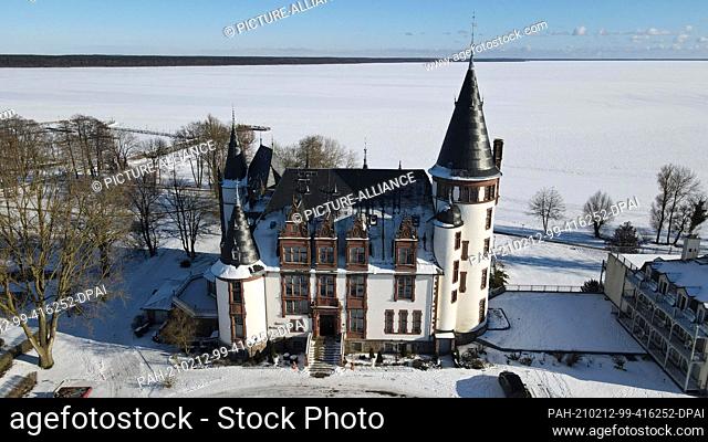 12 February 2021, Mecklenburg-Western Pomerania, Klink: The Müritz is covered with ice and snow up to the horizon, with Klink Castle in front