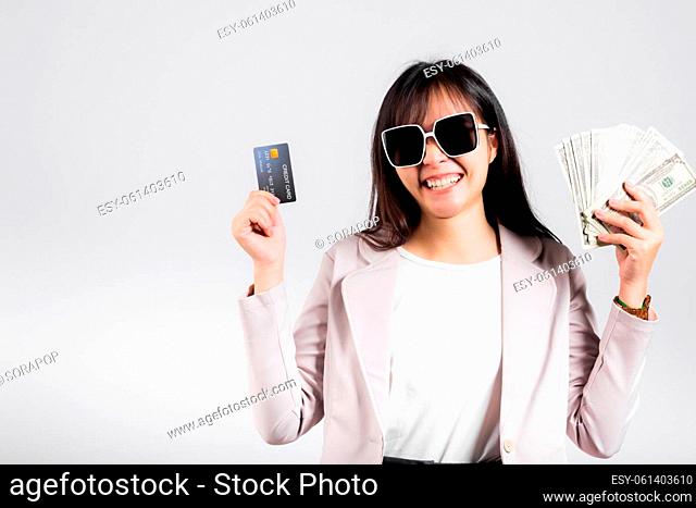 Woman with glasses confident smiling holding dollars money banknote and credit card for payment on hand, Portrait excited happy Asian young female show choose...