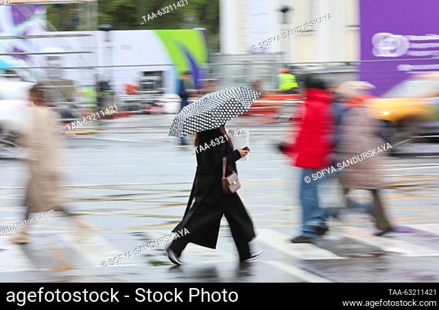 RUSSIA, MOSCOW - OCTOBER 9, 2023: A woman takes shelter under an umbrella during the rain. Sofya Sandurskaya/TASS