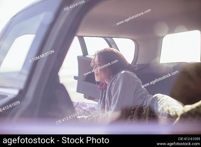 Serene woman laying at back of car