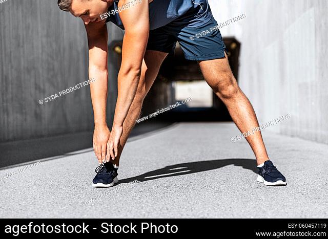 man doing sports and stretching outdoors
