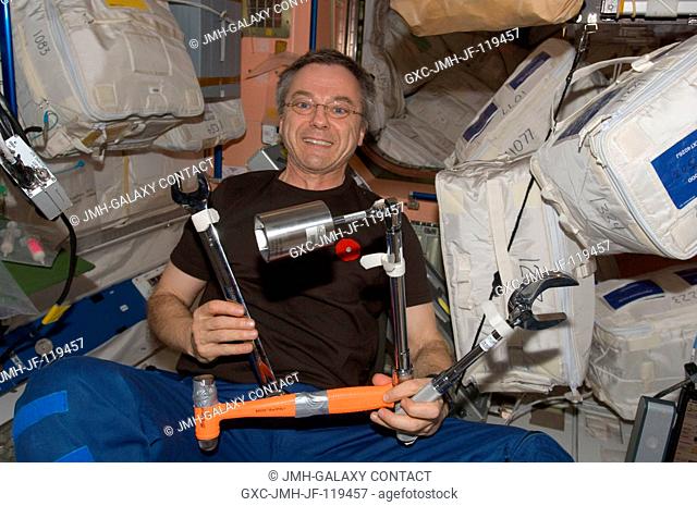 Canadian Space Agency astronaut Robert Thirsk, Expedition 21 flight engineer, holds various tools in the Unity node of the International Space Station