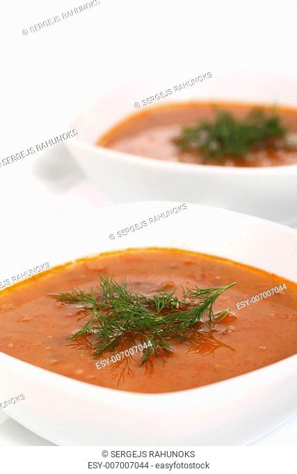 Image of two bowls of hot red soup isolated on white background