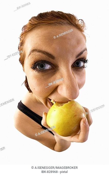 Woman biting into an apple, fish-eye lens