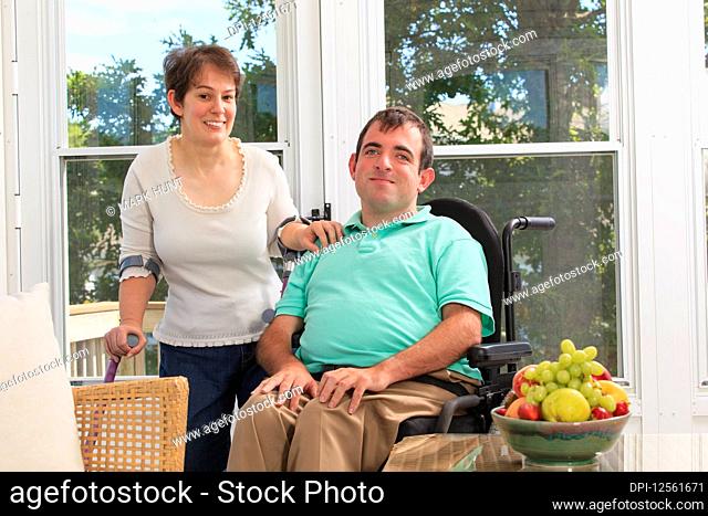 Portrait of a young couple with disabilities, woman using mobility aids and man in a wheelchair