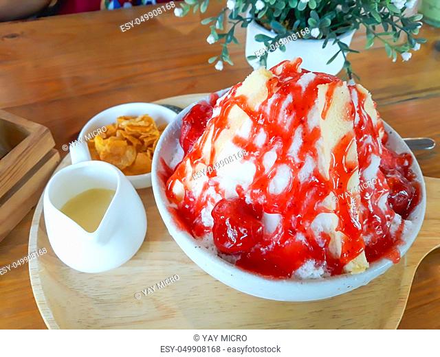 Kakigori or Bingsu strawberry cheesecake on wooden table