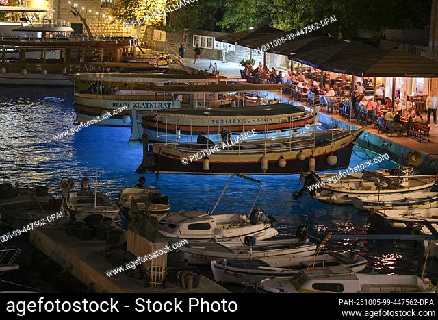PRODUCTION - 28 September 2023, Croatia, Bol: The small harbor with boats and cafes and restaurants in Bol on the island of Brac