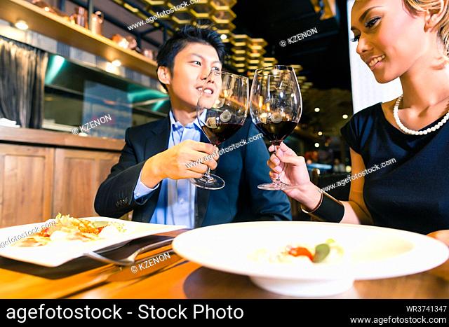 Asian couple toasting in restaurant