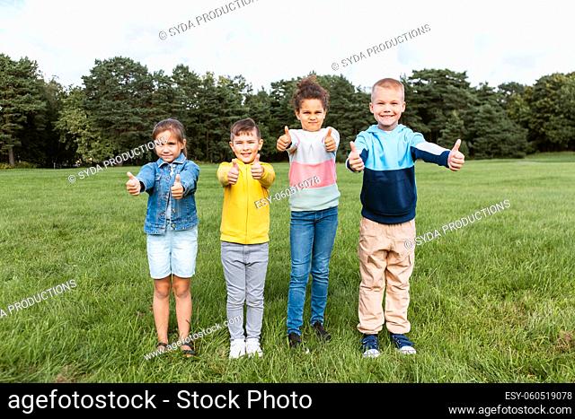 happy children showing thumbs up at park