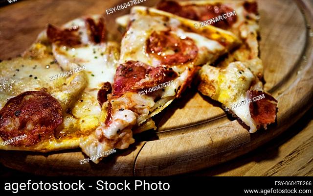 Pizza. Three pieces of delicious pizza. Pepperoni pizza on a wooden stand
