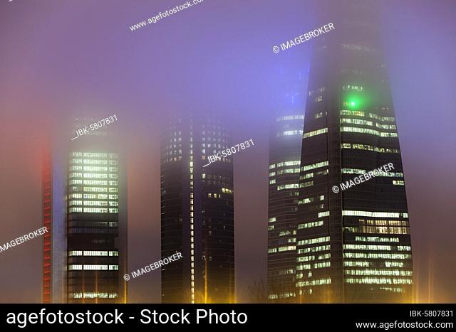 Cuatro Torres Business Area Office building illuminated in evening fog, Madrid, Spain, Europe