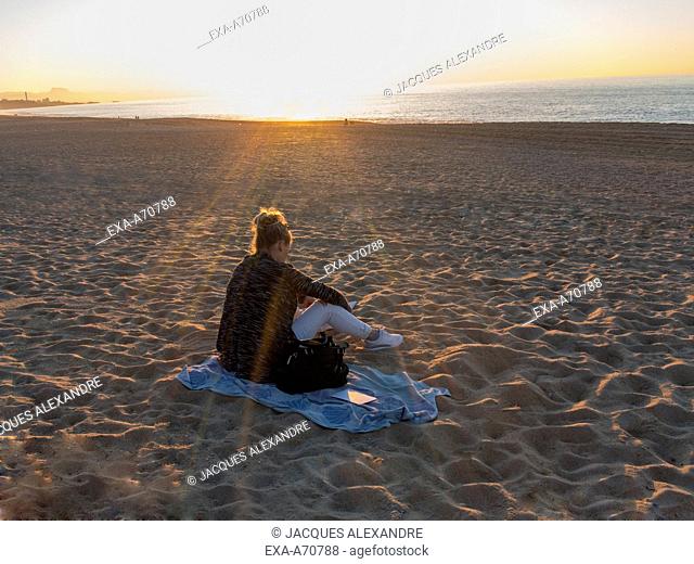 Woman reading book at beach