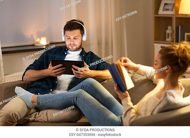 couple with tablet computer and book at home