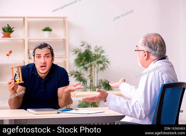 Young male patient visiting old doctor in time management concept