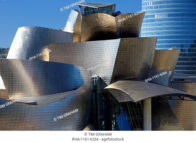 Architect Frank Gehry's Guggenheim Museum futuristic design in titanium and glass and Iberdrola Tower behind at Bilbao, Spain