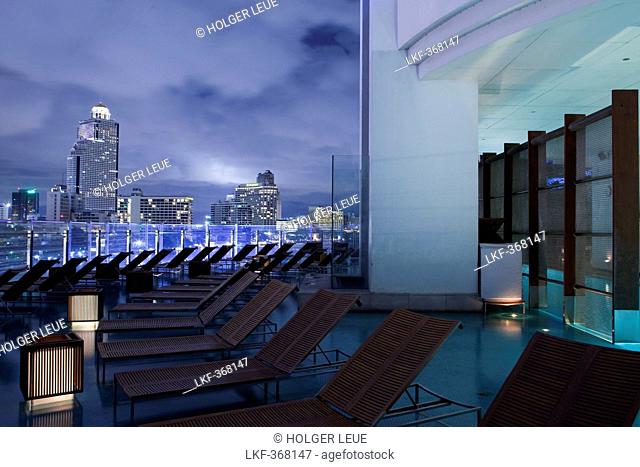 Lounge chairs and outdoor swimming pool at Millennium Hilton Hotel, Bangkok, Thailand