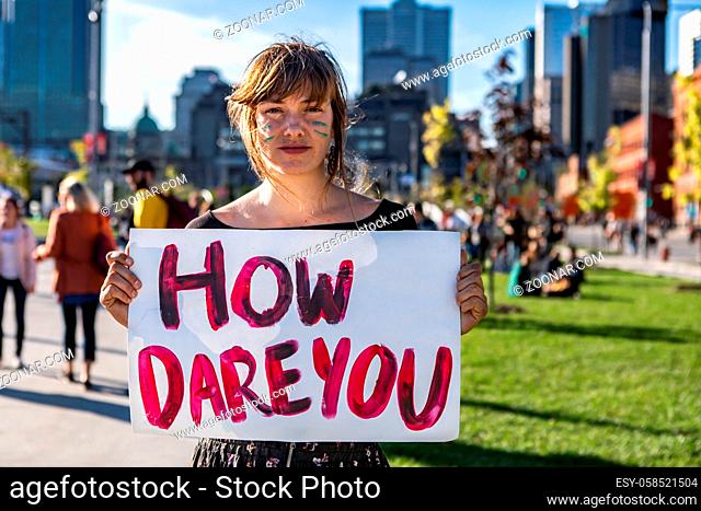 A close up view of an eco warrior during a climate rally on a street in Montreal, city center protest holding a poster saying how dare you, with copy space