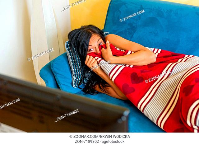 Eine junge Frau sieht einen traurigen Film im TV