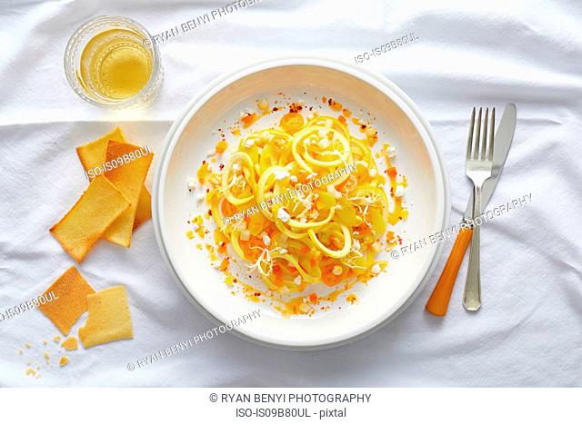 Spiralized yellow squash pasta with yellow cherry tomato, feta, orange pepper and a orange pepper coulis