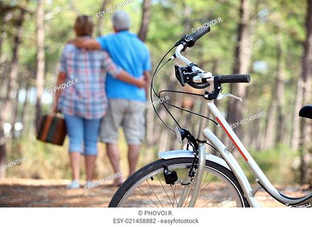 Couple taking a picnic to the woods by bike