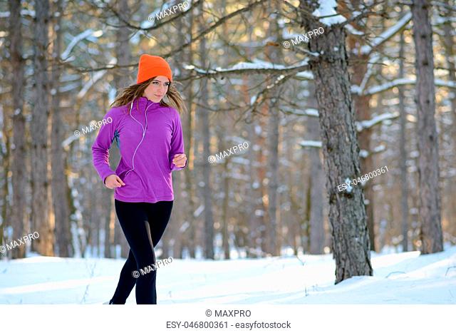 Young Woman Running in Beautiful Winter Forest at Sunny Frosty Day. Active Lifestyle Concept