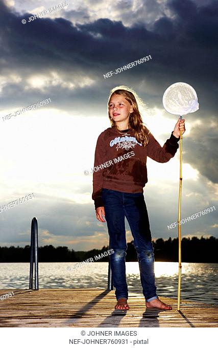 Girl with a bag net on a jetty, Sweden