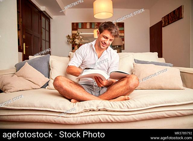 man, home, reading, cross-legged