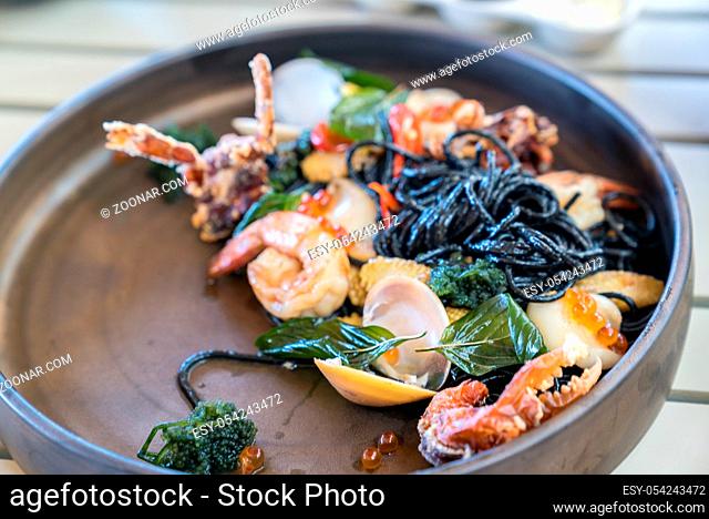The Mediterranean delicacy food. Black seafood pasta spaghetti with mussels calm shrimp and crab