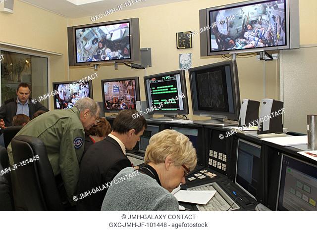 Russian engineers and instructors monitor their consoles as overhead television screens show the Expedition 3334 prime crew members conducting final...