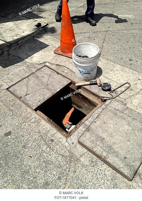 Worker under street manhole