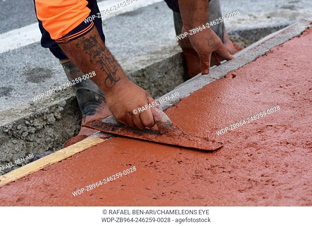 KAITAIA, NZ JAN 23:Road worker use finishing trowel tool on Jan 23 2014.The Road Maintenance crew has the responsibility for the day-to-day maintenance needs of...
