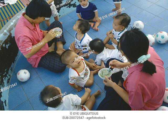 Staff feeding young children in Vienping Orphanage