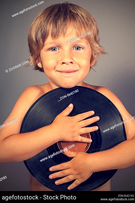 A boy with a record smiles