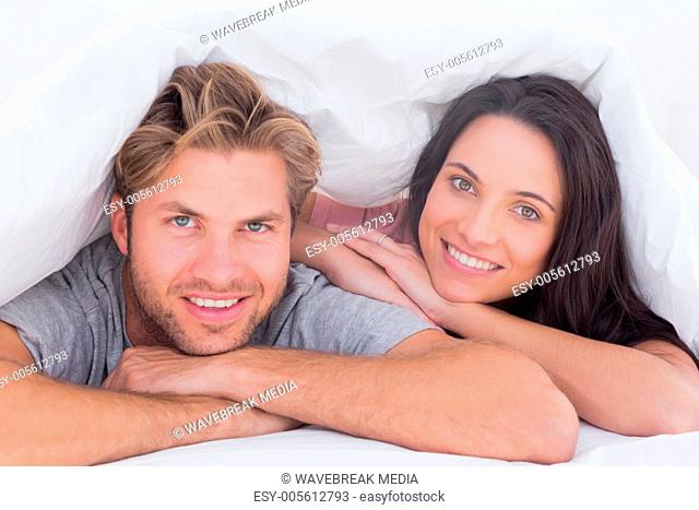 Beautiful couple smiling under the cover