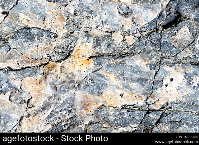 Cracked stone surface grey and brown color. Detailed nature background or pattern texture taken in natural environment. Weathered many years