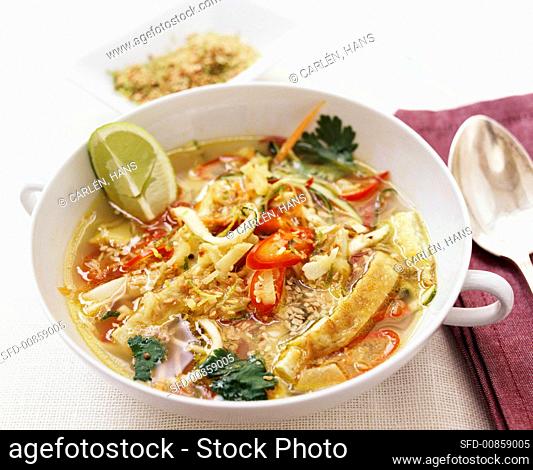 Thai soup with omelette strips and toasted coconut
