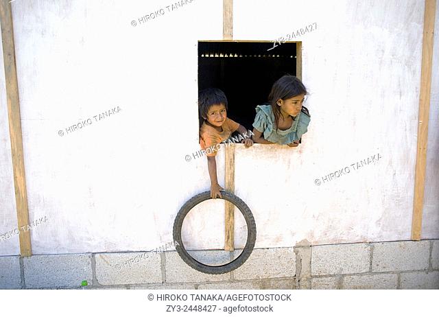 A maya indigenous family at window of their home in Aqua Escondida, Solola, Guatmeala