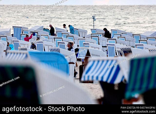 26 July 2023, Mecklenburg-Western Pomerania, Rostock: Empty beach chairs stand on the Baltic coast in Warnemünde. Stormy