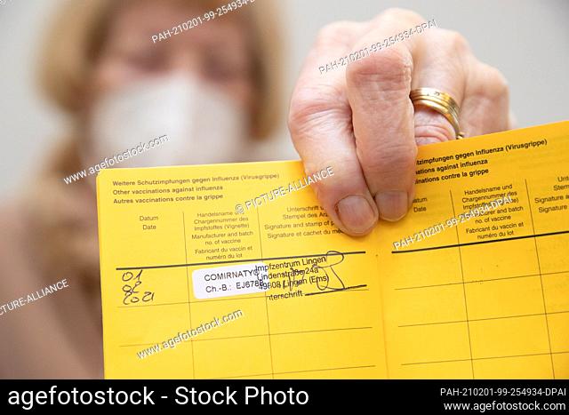 01 February 2021, Lower Saxony, Lingen: Senior citizen Maria Hesemann-Peters holds her vaccination certificate (vaccination book) with the sticker of a...