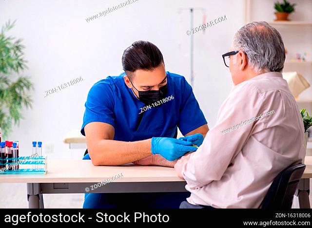 Old patient visiting young male doctor in blood transfusion concept
