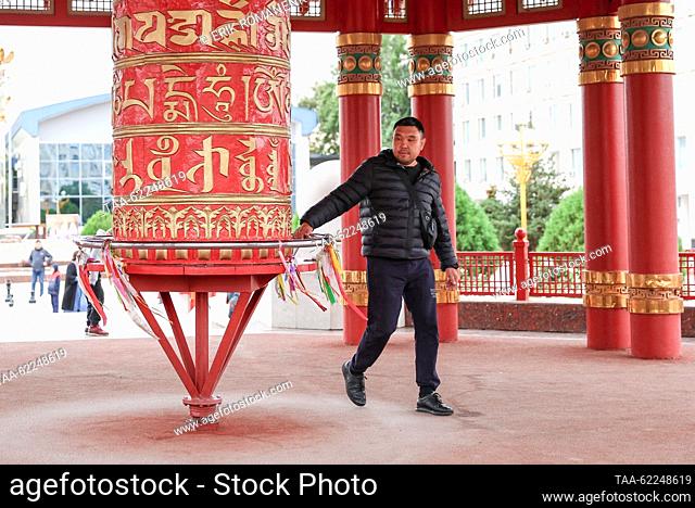 RUSSIA, ELISTA - SEPTEMBER 16, 2023: A man at a prayer wheel at the Pagoda of Seven Days in Lenin Square. Erik Romanenko/TASS