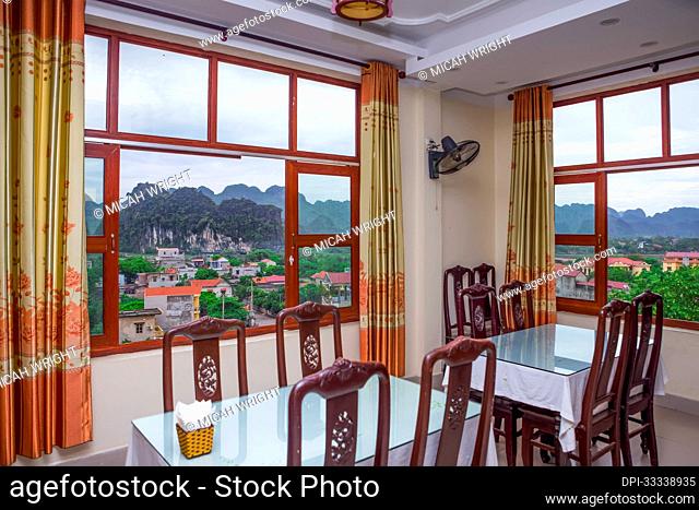 Views over the stunning countryside of Ninh Binh from a restaurant window, with its limestone mountains that have numerous caves and grottos covering the area;...