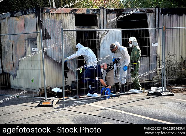 21 August 2020, Baden-Wuerttemberg, Meckesheim: Arson investigators work in front of burnt-out living quarters. Two people died in the fire that destroyed a...