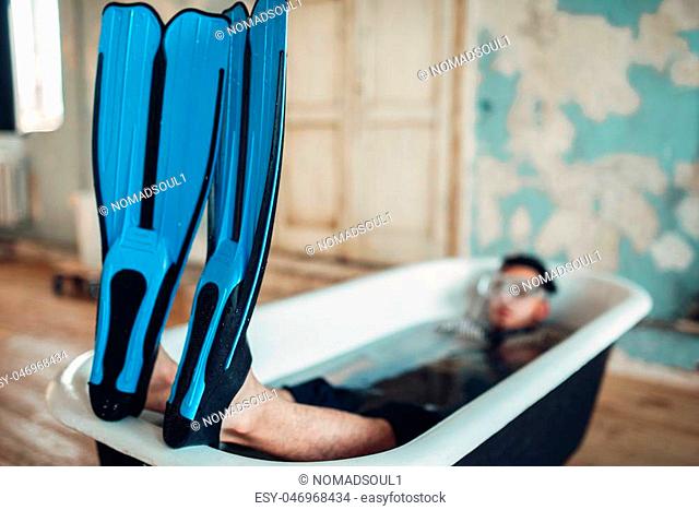 Funny businessman in flippers and mask lies in bathtub, humor. Business lottery concept