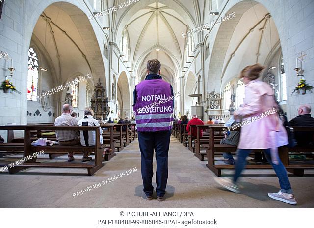08 April 2018, Germany, Muenster: An emergeny attendant standing in the cathedral at an oecumenical service. A man drove in to a group of people in front of a...
