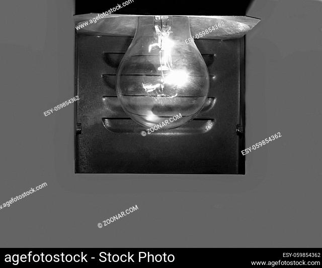 Burning electric lamp on a grey background