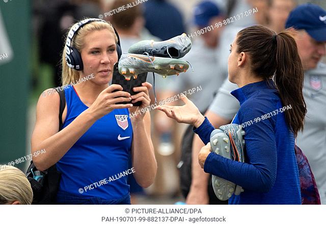 01 July 2019, France (France), Lyon: Football, women: World Cup, national team, USA, final training: Allie Long (l) films Alex Morgan throwing up her shoes