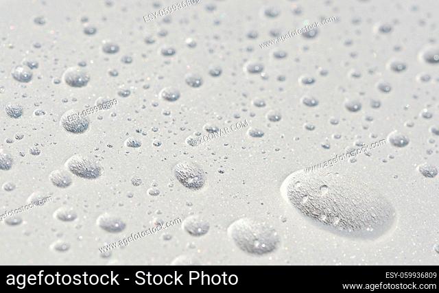 Drops of water close-up on textured plastic surface as background
