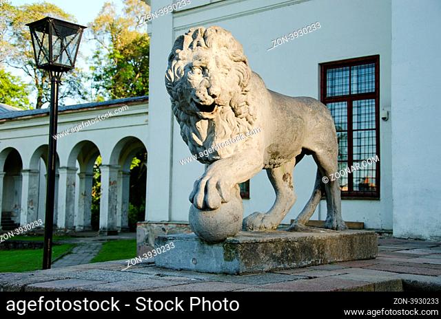 Retro stone lion sunlight with sun in park hold round ball with claw